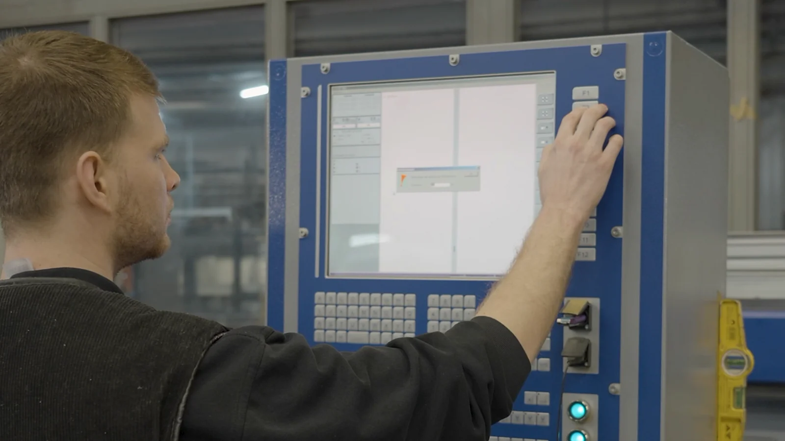 Opérateur travaillant sur une commande numérique en atelier